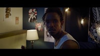 a man is standing in a room with lights on