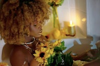 a woman in a bath tub with sunflowers and candles